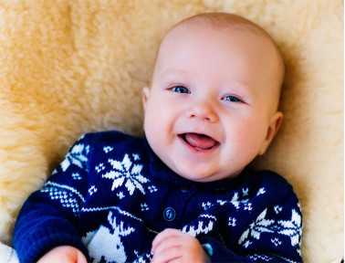 Baby laughing on medical sheepskin